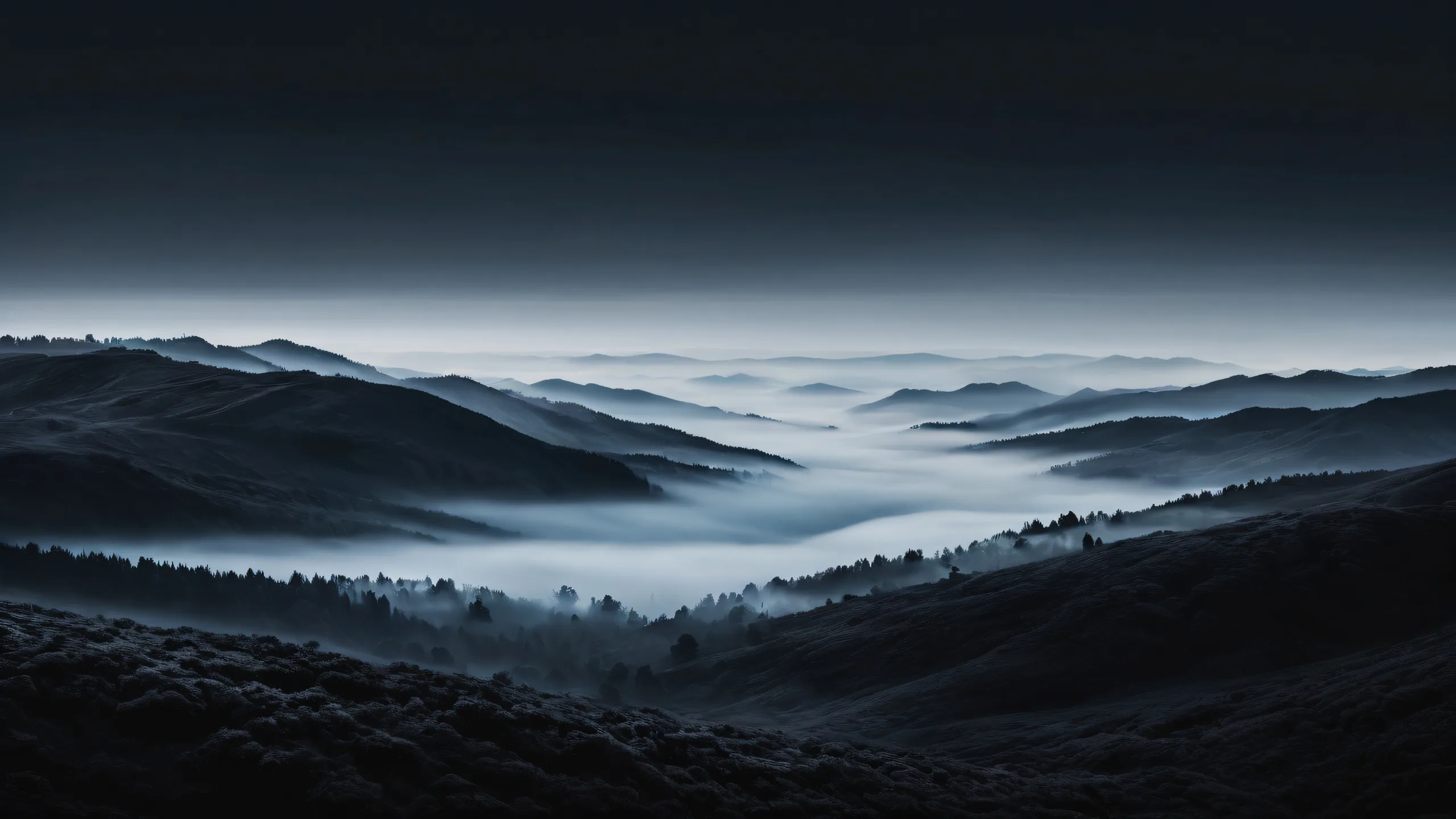 Foggy landscape desktop wallpaper featuring deep perfect blacks and luminescent accents for a sleek dark mode aesthetic, suitable for macOS desktop use.